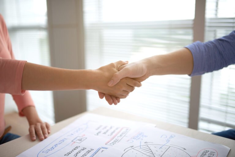 Business colleagues shaking hands after successful meeting